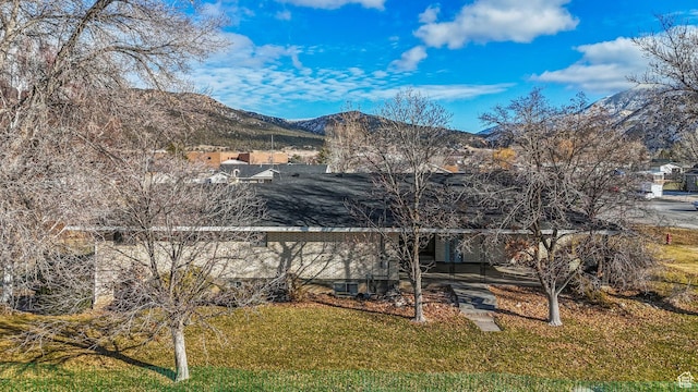 back of house featuring a lawn and a mountain view
