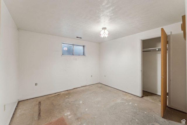 unfurnished bedroom with a closet and concrete flooring