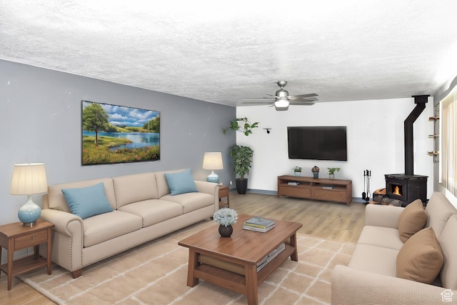 4752 E Max Rd, Downey, ID 83234 - living room with a textured ceiling, ceiling fan, light hardwood / wood-style flooring, and a wood stove