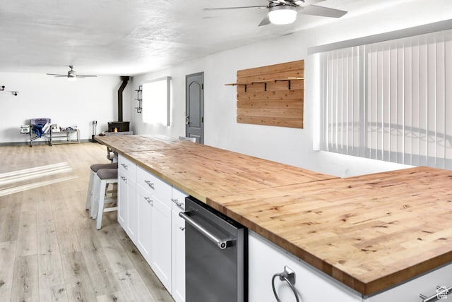 4752 E Max Rd, Downey, ID 83234 - kitchen with light wood-type flooring, butcher block countertops, a wood stove, and white cabinetry