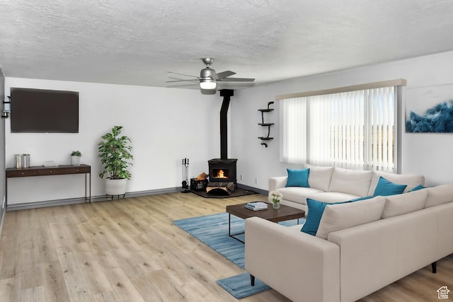4752 E Max Rd, Downey, ID 83234 - living room featuring ceiling fan, a textured ceiling, light wood-type flooring, and a wood stove