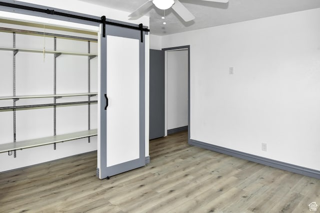 4752 E Max Rd, Downey, ID 83234 - unfurnished bedroom with hardwood / wood-style flooring, ceiling fan, a barn door, and a closet