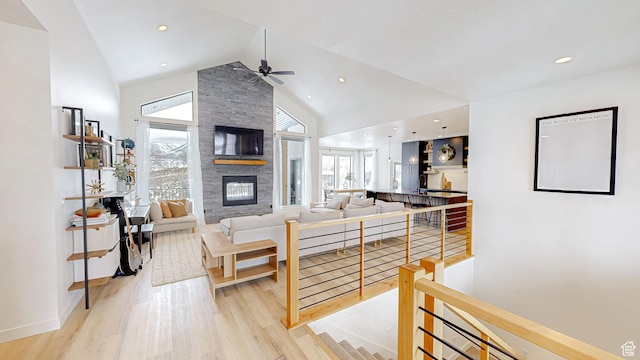 1244 N Washougal, Elk Ridge, UT 84651 - living area with a stone fireplace, high vaulted ceiling, a ceiling fan, light wood finished floors, and baseboards