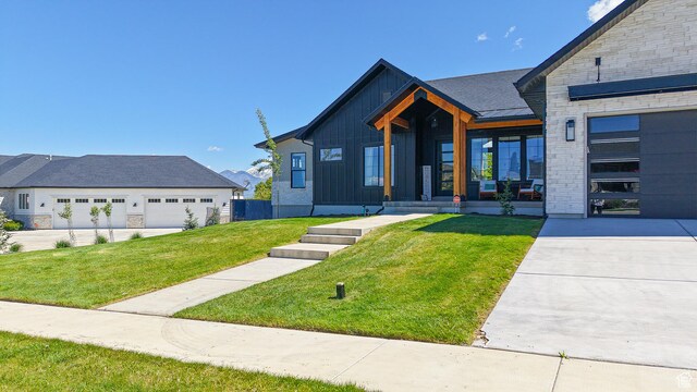 1244 N Washougal, Elk Ridge, UT 84651 - view of front of property featuring a front lawn, stone siding, covered porch, board and batten siding, and a garage