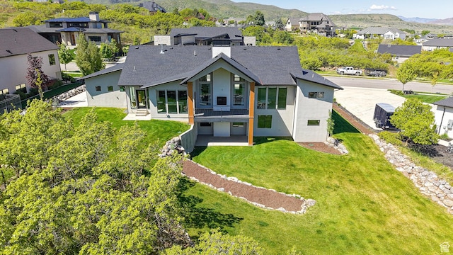 1244 N Washougal, Elk Ridge, UT 84651 - rear view of house with stucco siding, a mountain view, a residential view, a lawn, and roof with shingles