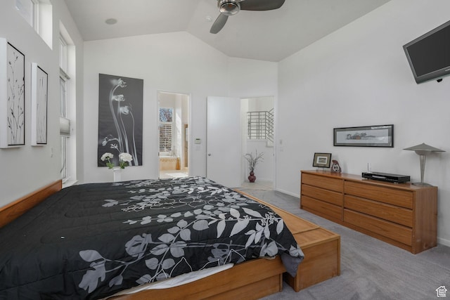 bedroom with ceiling fan, light colored carpet, ensuite bathroom, and lofted ceiling