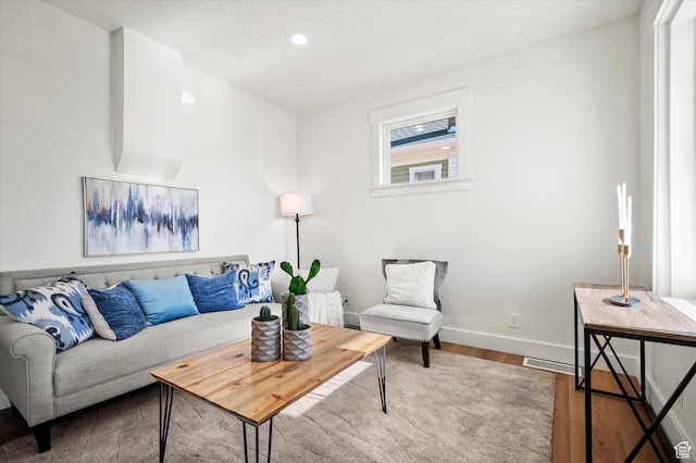 living room featuring baseboards, wood finished floors, and recessed lighting