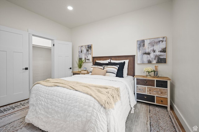 bedroom with baseboards, wood finished floors, and recessed lighting