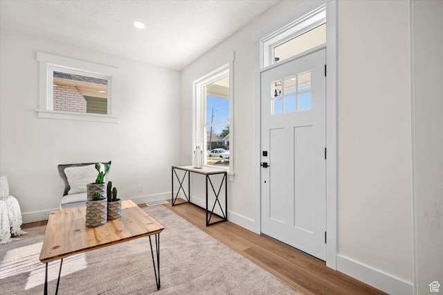 entryway featuring baseboards, recessed lighting, and light wood-style floors