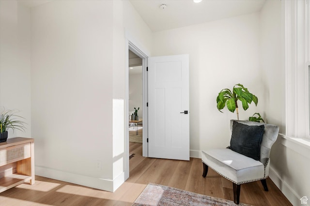 sitting room featuring light wood finished floors and baseboards