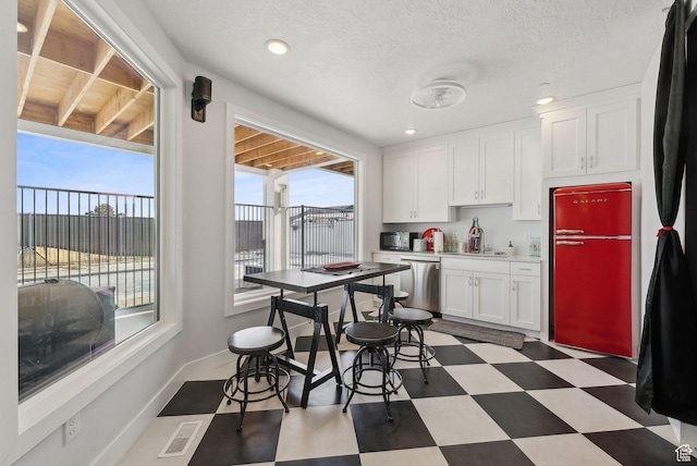 13599 S White Pony Rd W, Herriman, UT 84096 - kitchen featuring white cabinetry, fridge, dishwasher, a textured ceiling, and sink