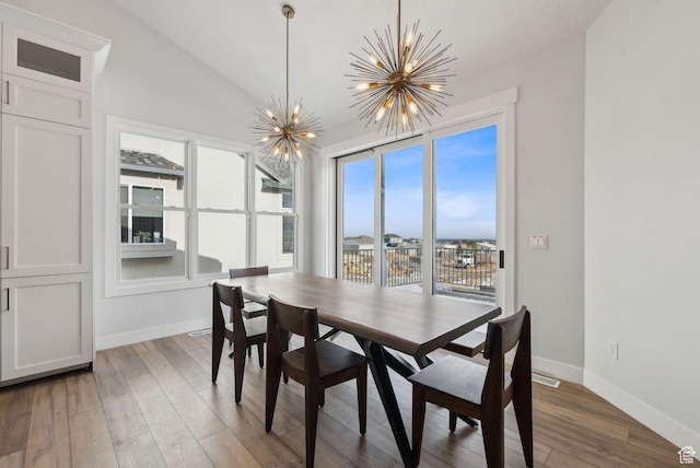13599 S White Pony Rd W, Herriman, UT 84096 - dining area with an inviting chandelier, lofted ceiling, and wood-type flooring