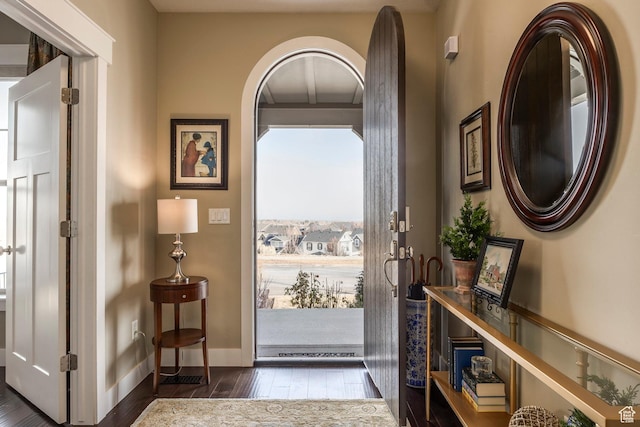foyer entrance featuring dark wood-style floors and baseboards