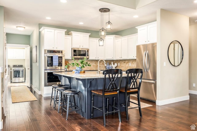 kitchen with stainless steel appliances, tasteful backsplash, and white cabinets