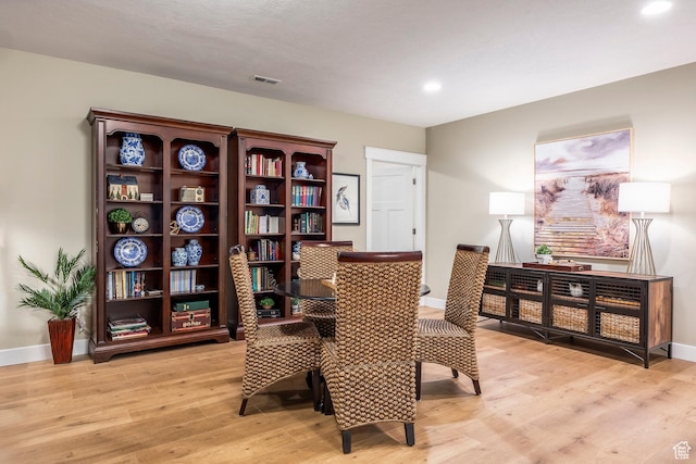 living area featuring visible vents, light wood-type flooring, and baseboards