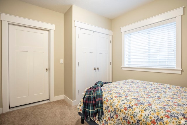 carpeted bedroom featuring a closet and baseboards