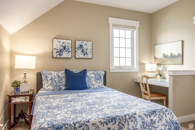 bedroom with baseboards, lofted ceiling, and carpet floors