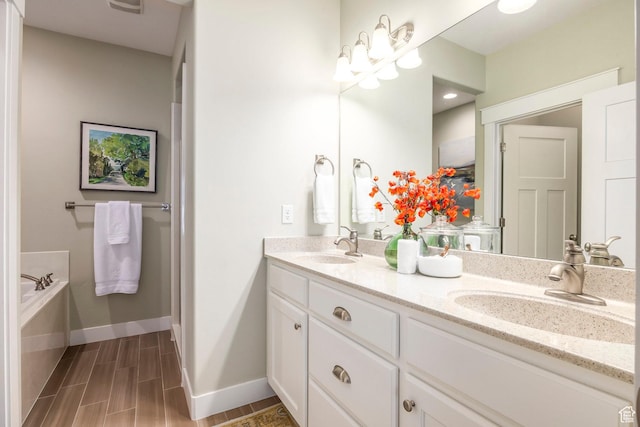 full bathroom with wood tiled floor, double vanity, baseboards, and a sink