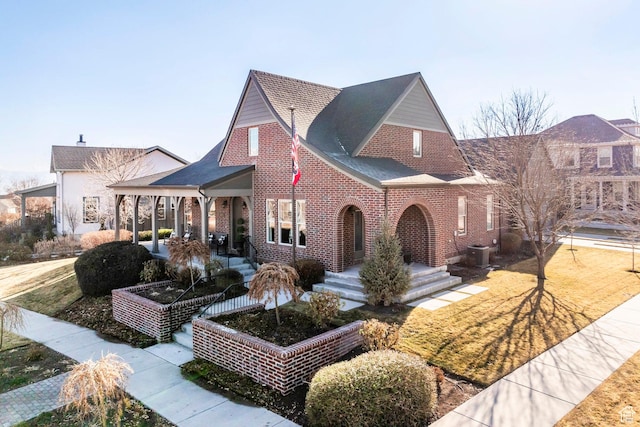 view of front of home with cooling unit, brick siding, and a shingled roof