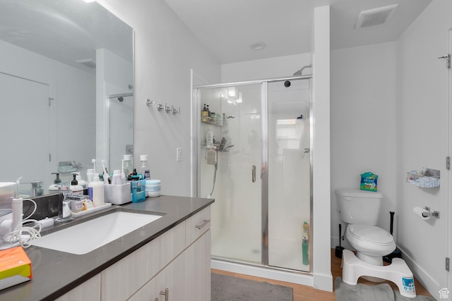 1570 S Main St Unit 102, Salt Lake City, UT 84115 - bathroom featuring toilet, an enclosed shower, vanity, and wood-type flooring