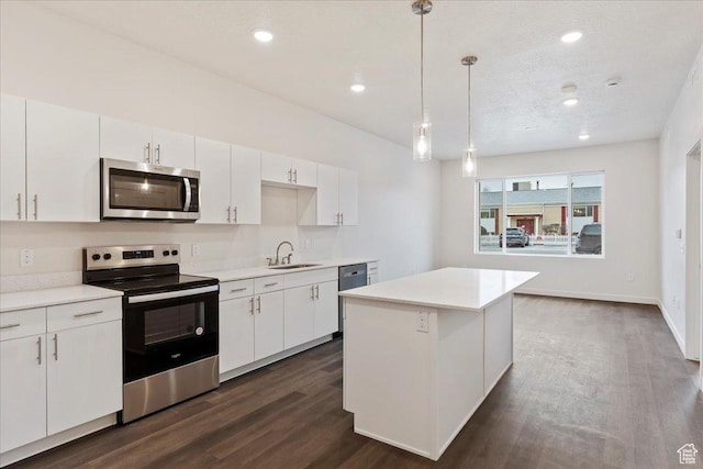 kitchen with a sink, dark wood-type flooring, appliances with stainless steel finishes, and white cabinetry