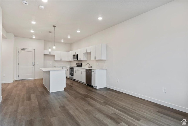 kitchen featuring a sink, a center island, stainless steel appliances, white cabinets, and light countertops