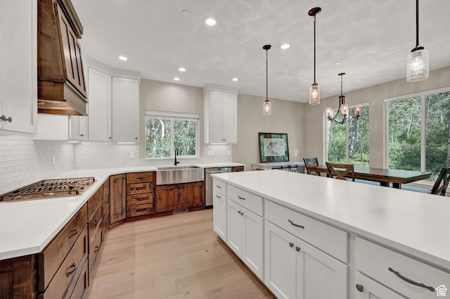 10694 E Cottonwood Ln Unit 539, Heber City, UT 84032 - kitchen featuring light wood-type flooring, stainless steel appliances, a sink, light countertops, and tasteful backsplash