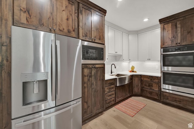 10694 E Cottonwood Ln Unit 539, Heber City, UT 84032 - kitchen with light countertops, light wood-style flooring, appliances with stainless steel finishes, white cabinets, and a sink