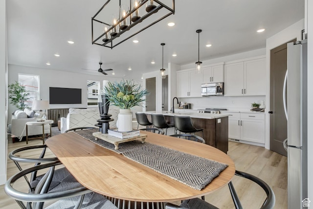 dining area featuring light wood-type flooring, a ceiling fan, and recessed lighting