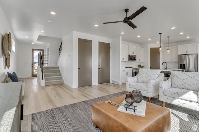 living area featuring light wood-type flooring, ceiling fan, baseboards, and recessed lighting