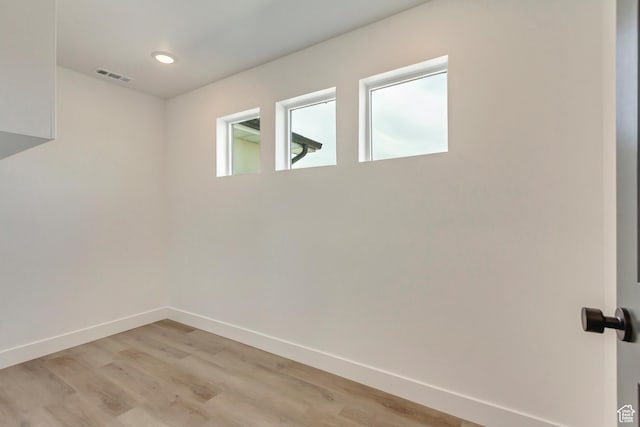 interior space with light wood-style floors, baseboards, and visible vents