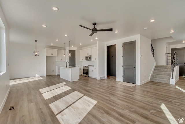 unfurnished living room with baseboards and light wood-type flooring
