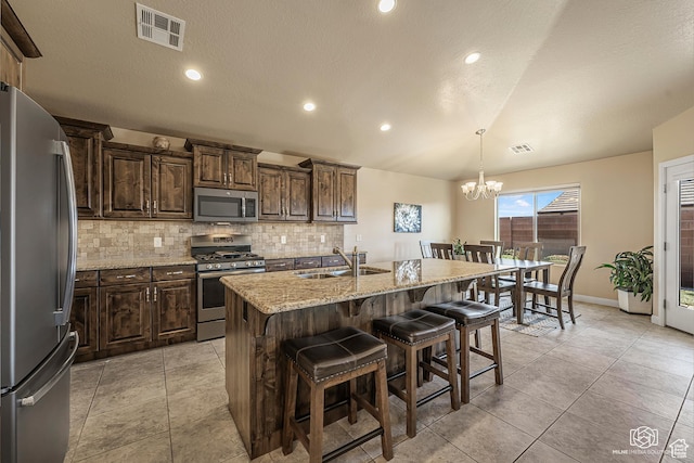 1987 S 2940 E, St George, UT 84790 - kitchen featuring hanging light fixtures, stainless steel appliances, a center island with sink, a breakfast bar area, and sink
