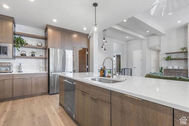 51 N Gray Fox Cir, Kaysville, UT 84037 - kitchen with light stone countertops, decorative light fixtures, stainless steel appliances, light hardwood / wood-style floors, and sink