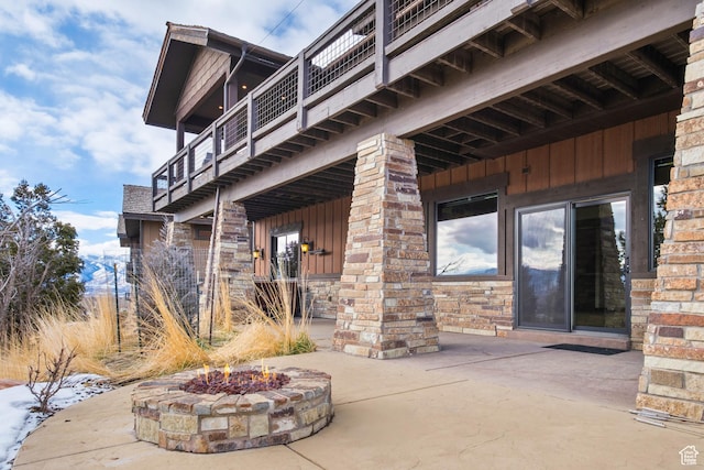 exterior space with a balcony and a fire pit