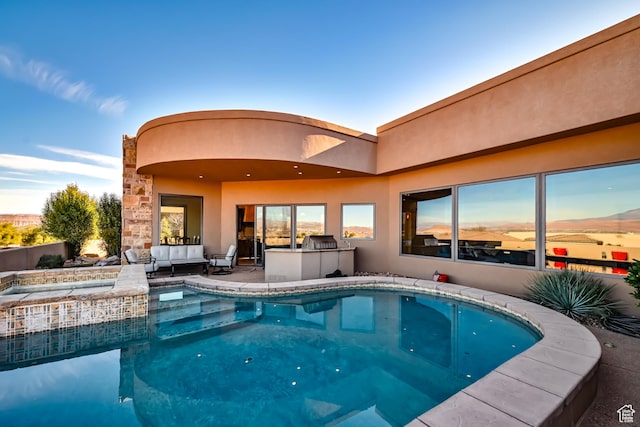 view of swimming pool with an outdoor kitchen and a hot tub