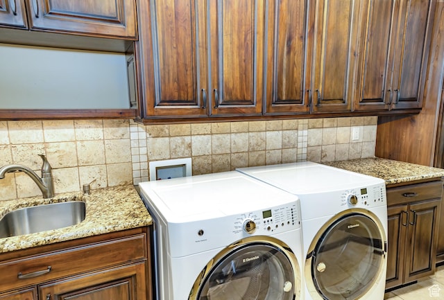 clothes washing area featuring cabinets, light tile patterned flooring, washing machine and clothes dryer, and sink