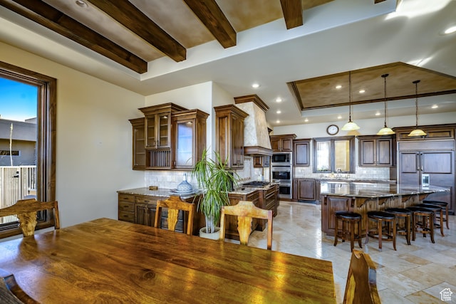 dining area featuring sink and beam ceiling