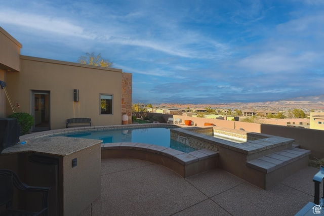 view of pool featuring a jacuzzi and a patio