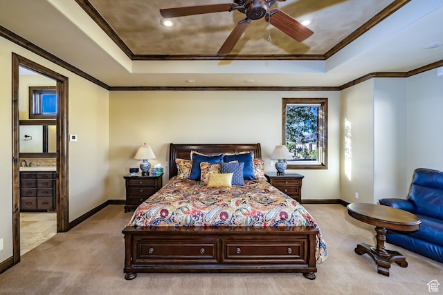 bedroom featuring ceiling fan, ensuite bathroom, a raised ceiling, and light carpet