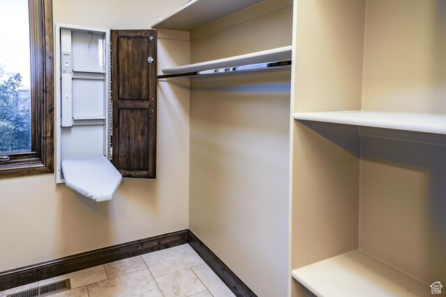 walk in closet with light tile patterned floors