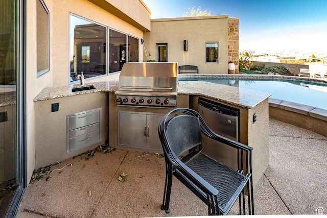 view of pool featuring area for grilling and sink