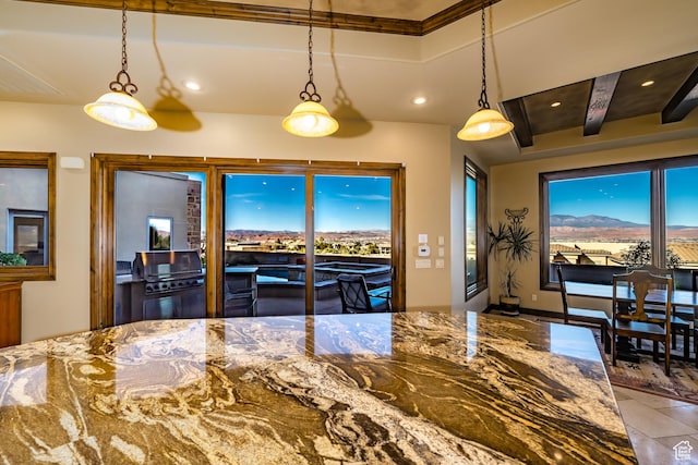 kitchen with stone countertops, pendant lighting, and a mountain view