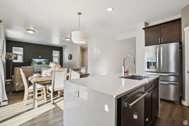 6343 W 7900 S, West Jordan, UT 84081 - kitchen featuring appliances with stainless steel finishes, sink, hanging light fixtures, dark hardwood / wood-style floors, and a center island with sink