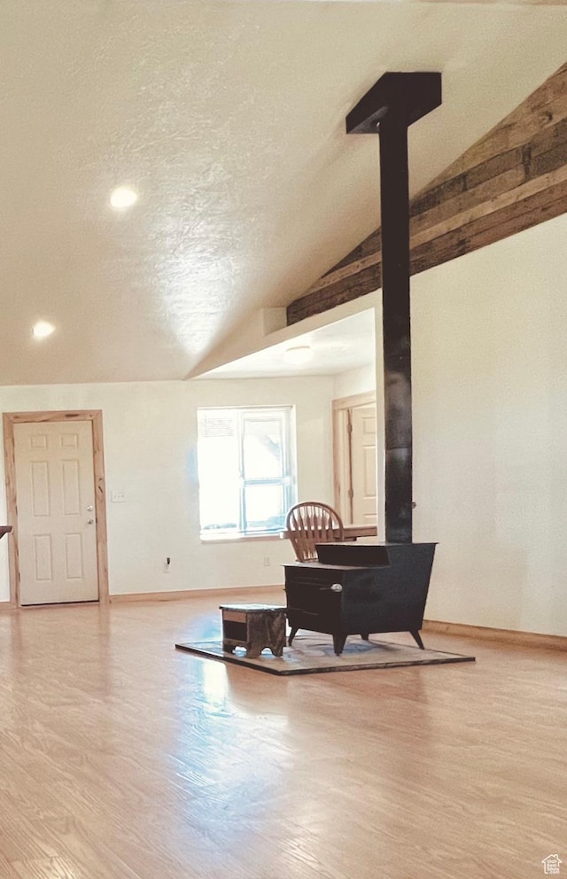 19600 N 8250 E, Mount Pleasant, UT 84647 - interior space featuring baseboards, vaulted ceiling, a wood stove, wood finished floors, and a textured ceiling