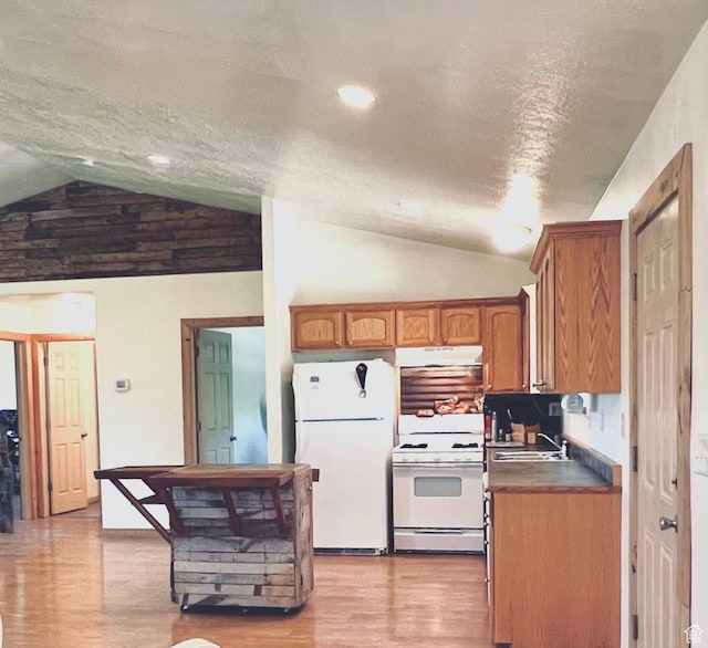 19600 N 8250 E, Mount Pleasant, UT 84647 - kitchen featuring under cabinet range hood, white appliances, brown cabinets, and vaulted ceiling