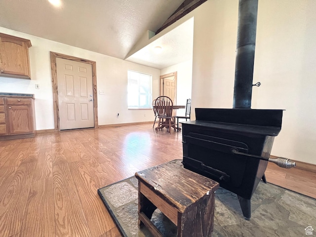 19600 N 8250 E, Mount Pleasant, UT 84647 - living area with light wood-style flooring, a wood stove, baseboards, and vaulted ceiling
