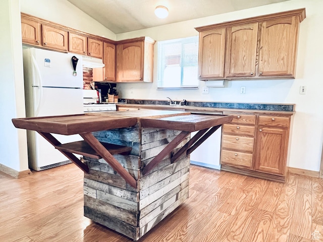 19600 N 8250 E, Mount Pleasant, UT 84647 - kitchen with white appliances, light wood-style flooring, vaulted ceiling, under cabinet range hood, and dark countertops