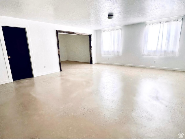 19600 N 8250 E, Mount Pleasant, UT 84647 - unfurnished bedroom with multiple windows, a textured ceiling, concrete floors, and baseboards
