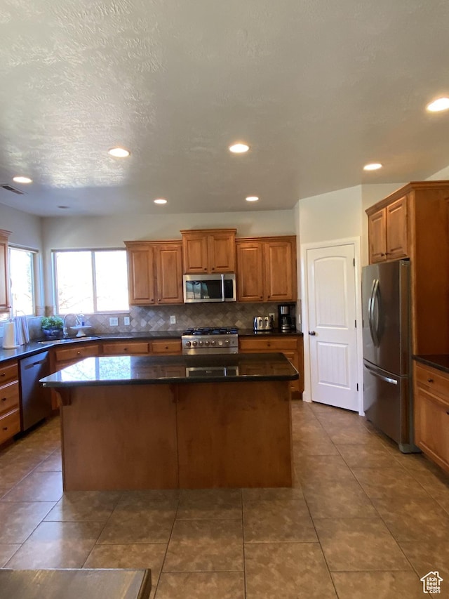 1918 S Mojave Dr, Washington, UT 84780 - kitchen with appliances with stainless steel finishes, tile patterned floors, tasteful backsplash, and a center island
